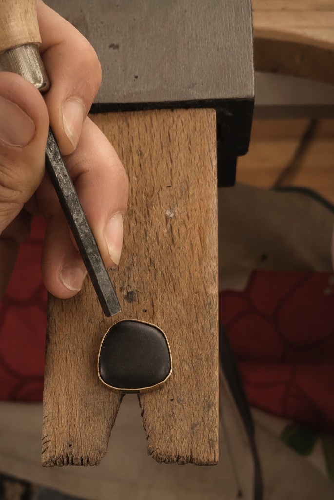 Pierre noire en cours de sertissage sur l'établi de bijoutier à l'atelier Petite Mer
